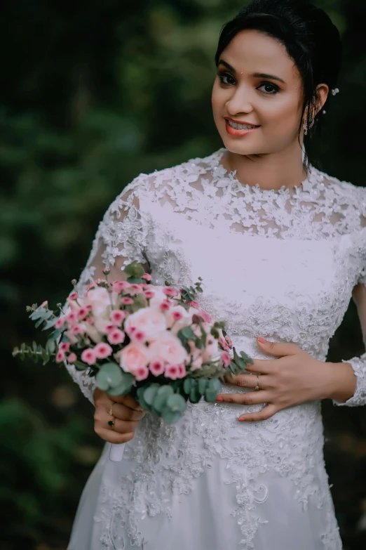 woman standing in the woods with flowers on her bouquet