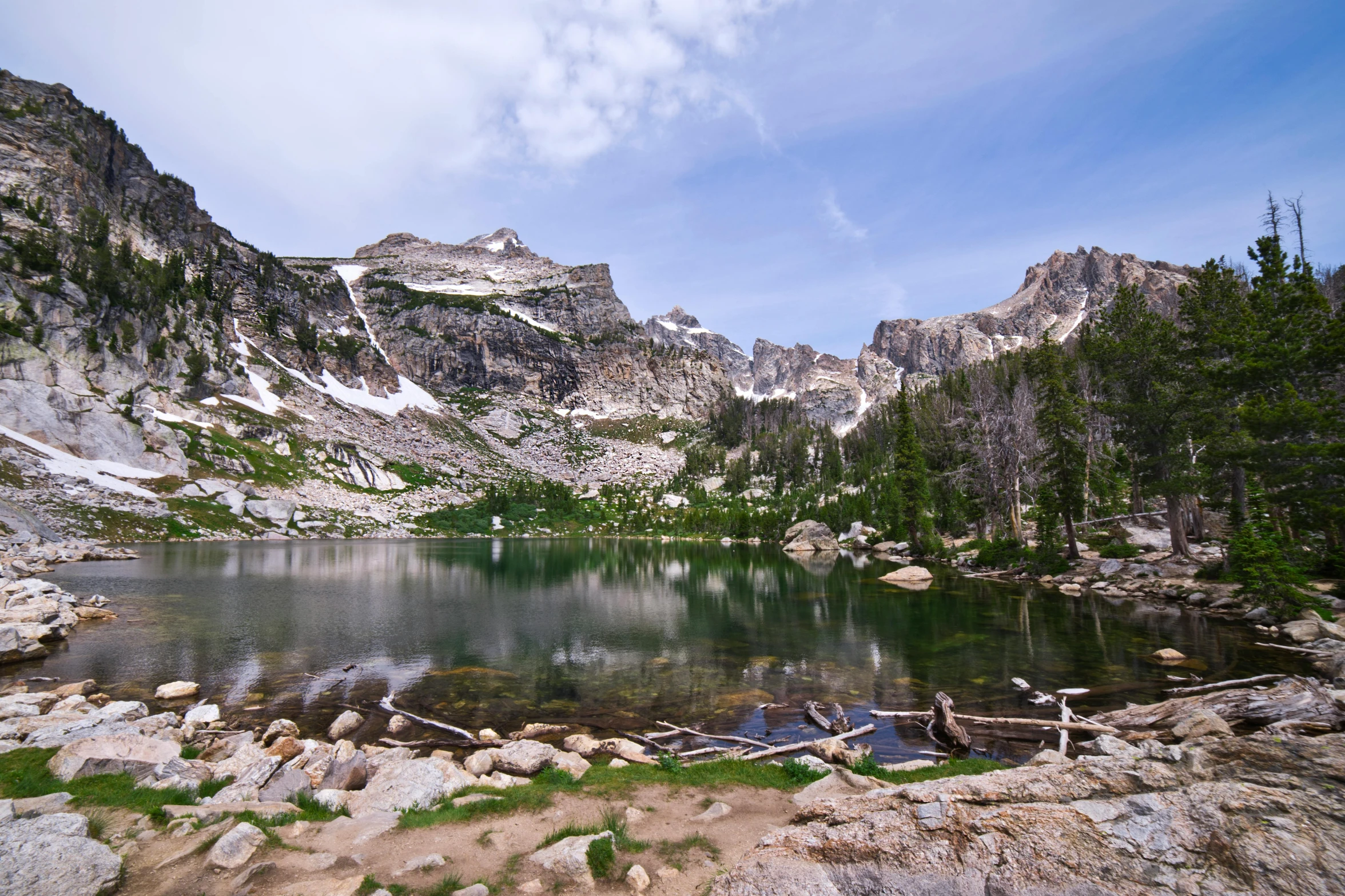 small lake surrounded by pine trees in mountains