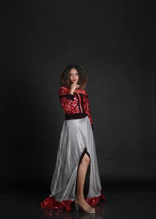 woman in a silver and red skirt with her arms around her face