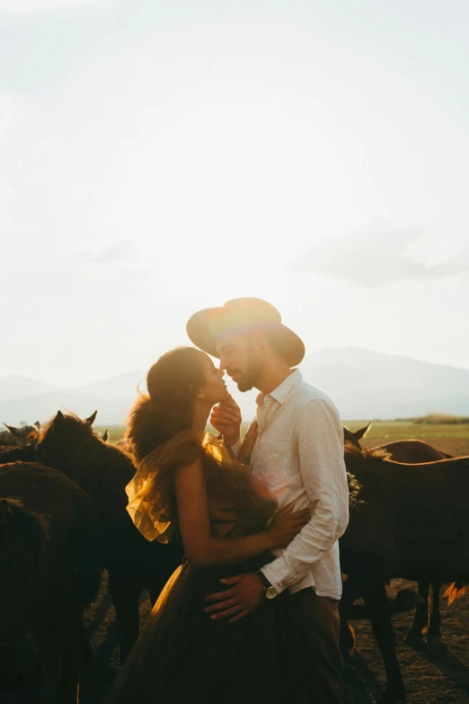 a young man kissing his partner in front of horses