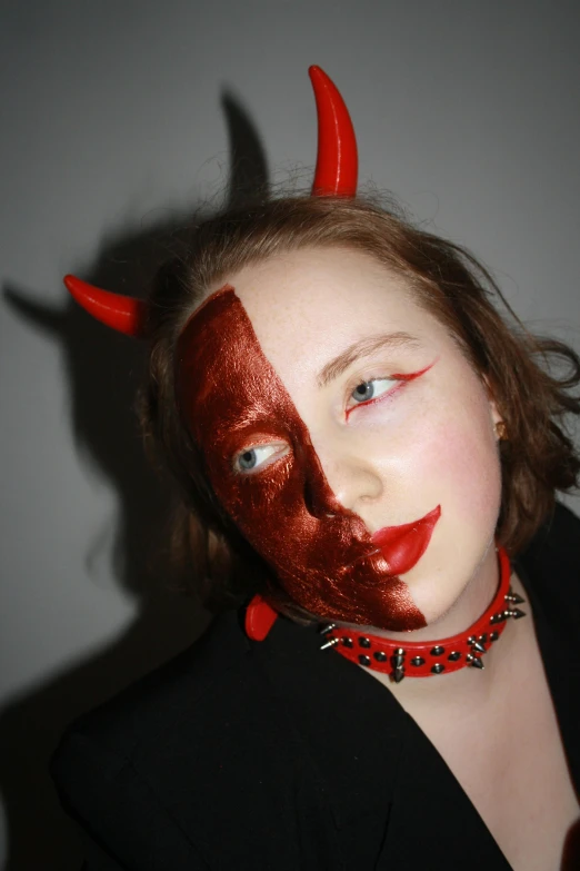 a woman has her face painted like a devil