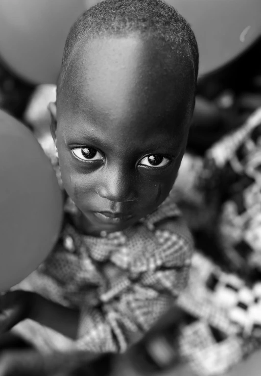 a little girl is standing in front of some balloons