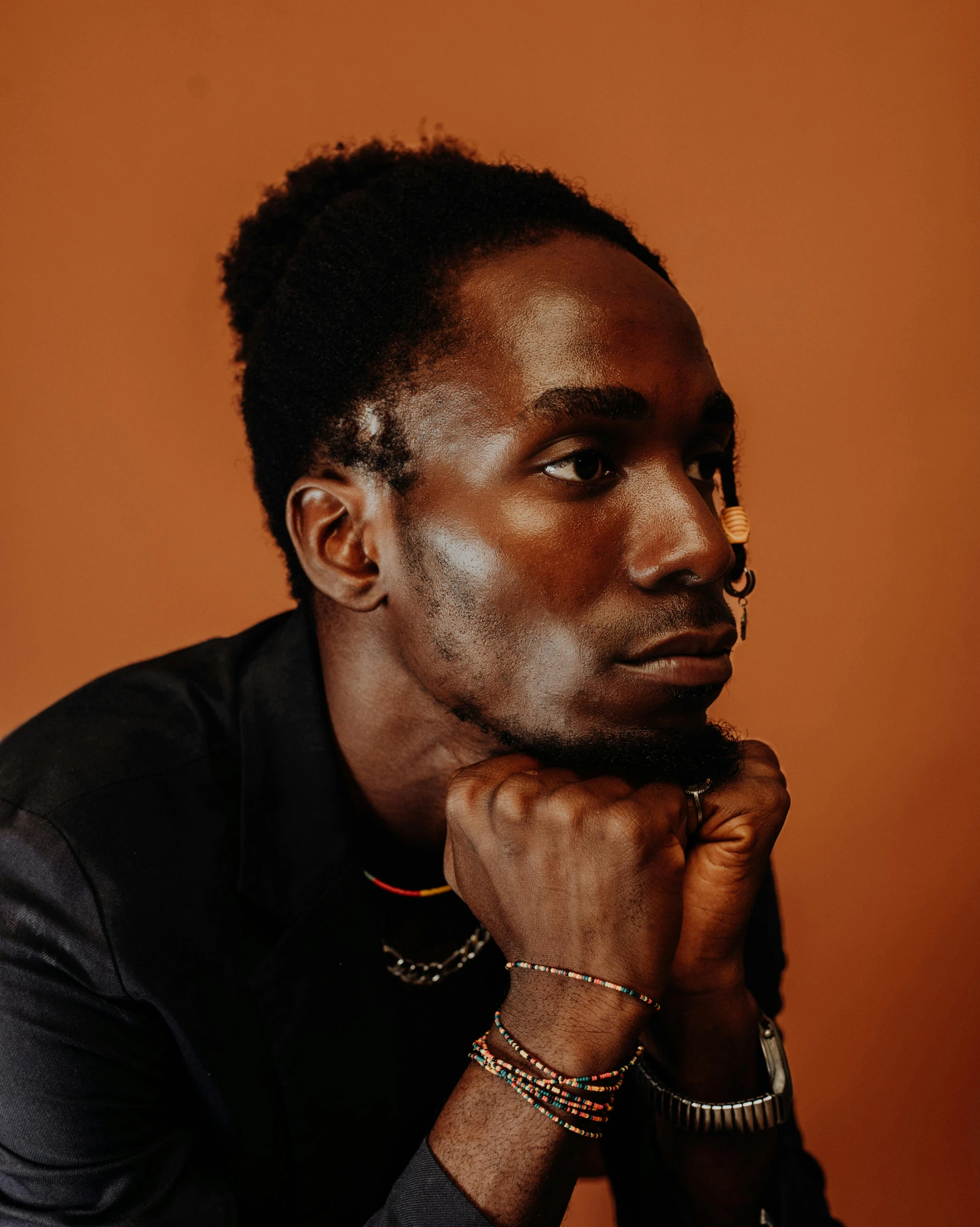 an african american male poses for the camera with his hand near his chin