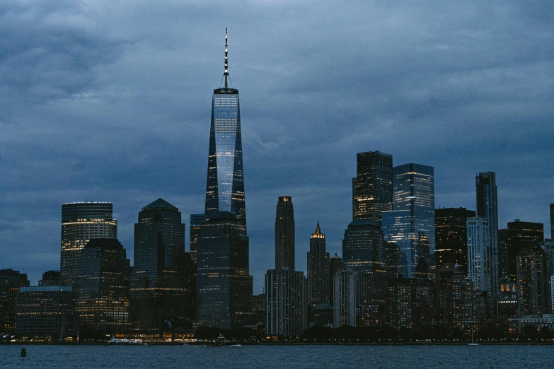 a dark city with skyscrs towering over the ocean