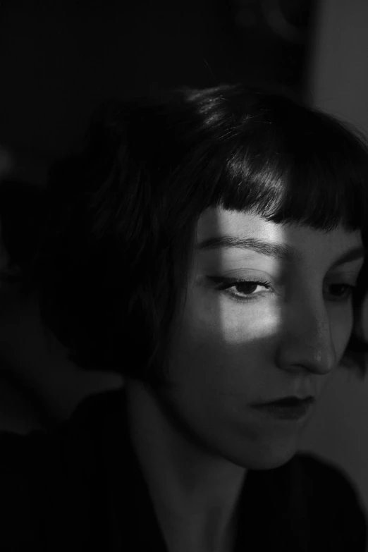 a person with short hair staring into the distance