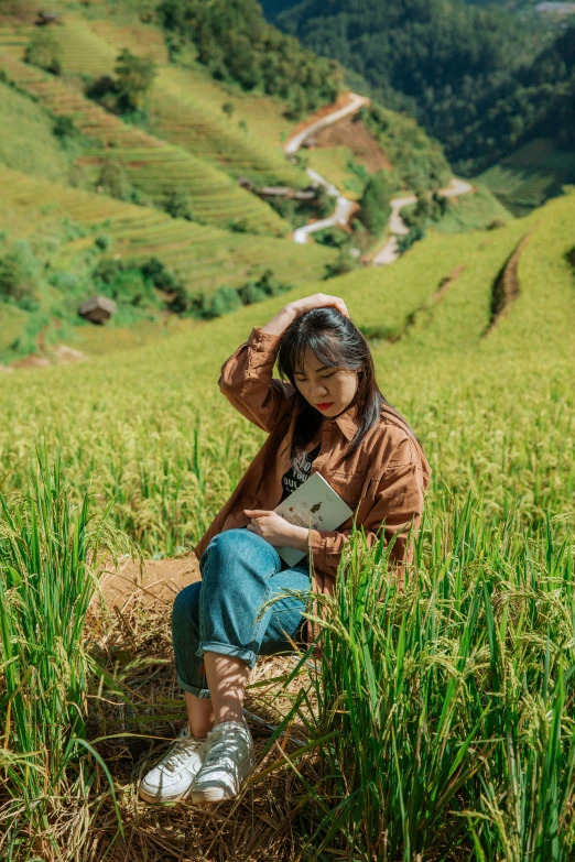 the girl is sitting alone in a field