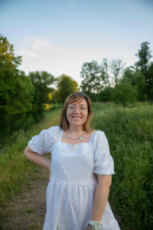 a woman posing for a picture in white dress