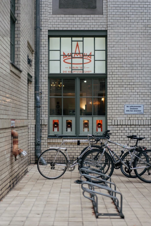 bikes parked outside of a building with parking meters next to them