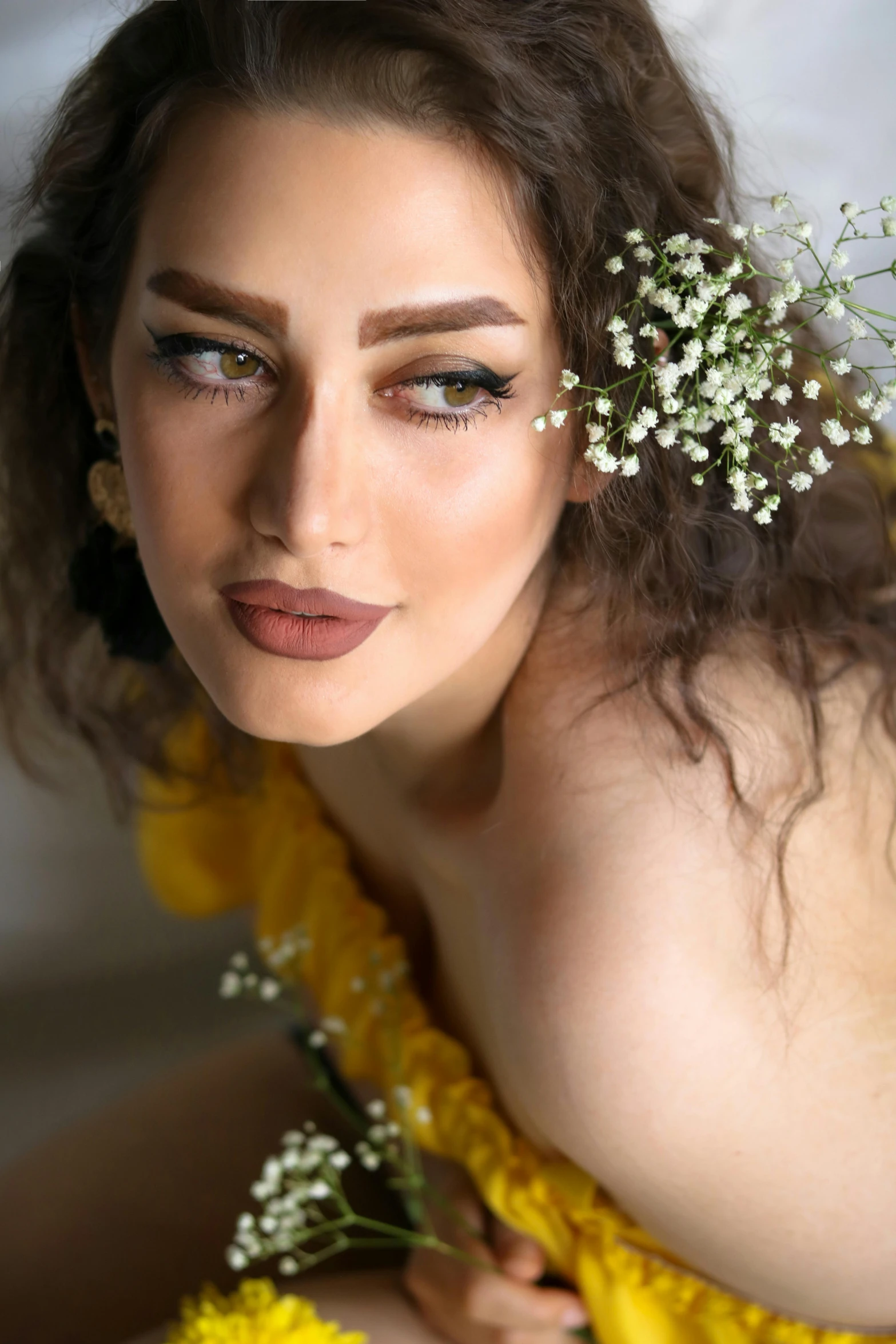 a woman with flowers on her head and the makeup is wearing an orange dress