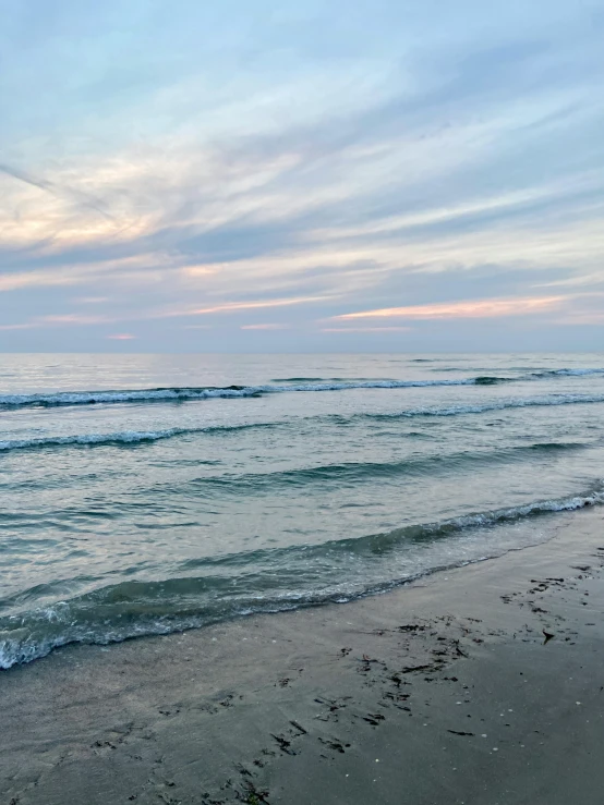 the beach is empty with the water flowing into the shore