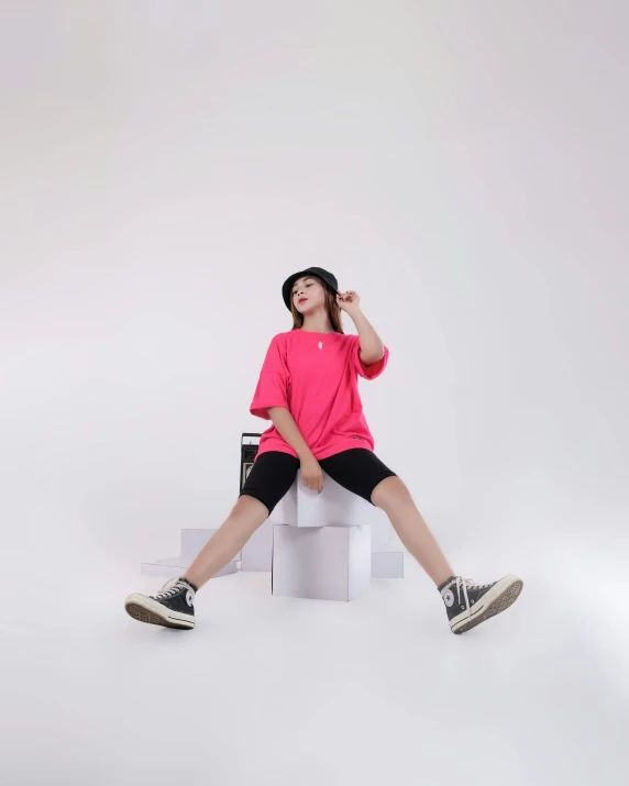 woman in pink and black sitting on white box