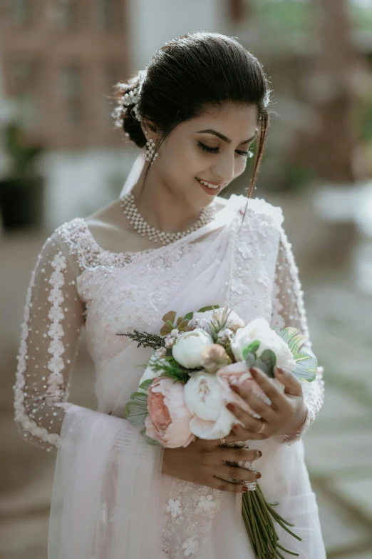 the woman smiles while holding a flower bouquet