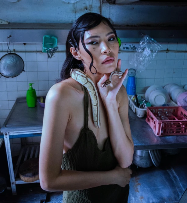 a woman smoking in a kitchen next to a counter