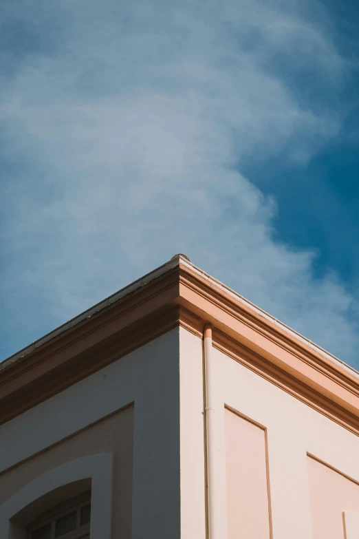 the corner of a tall building with a clock on it