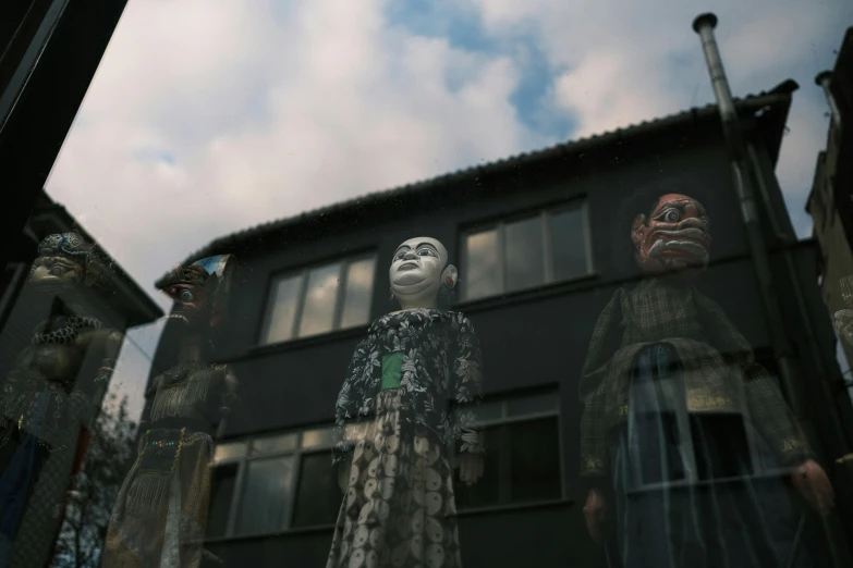 some fake dolls in front of a large building