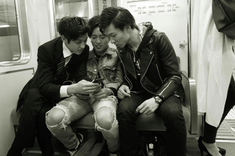 two men are sitting with a girl on a subway