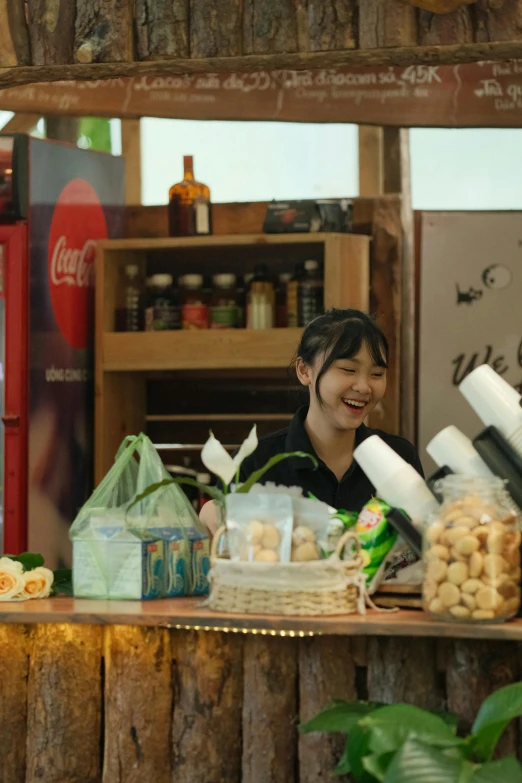 there is a woman sitting at the counter behind a cake