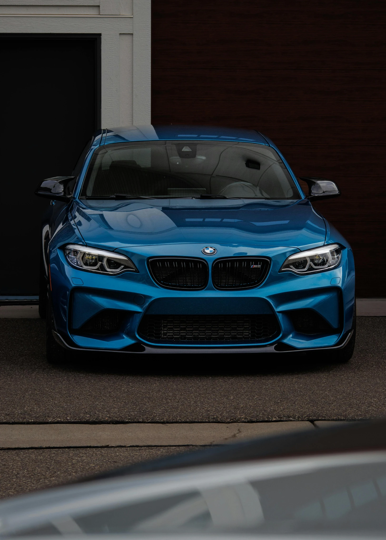 the front end of a blue car is seen