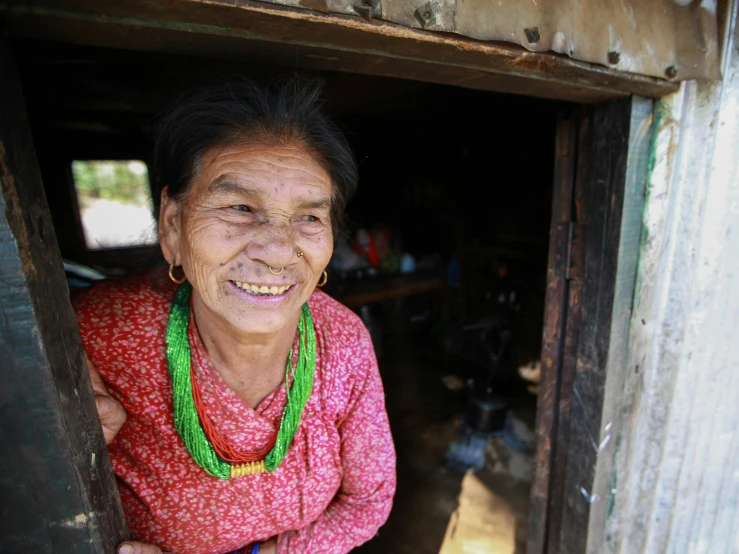 a lady with green necklaces in her doorway