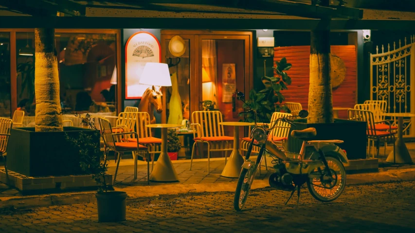 the man is standing by his bike outside of the restaurant