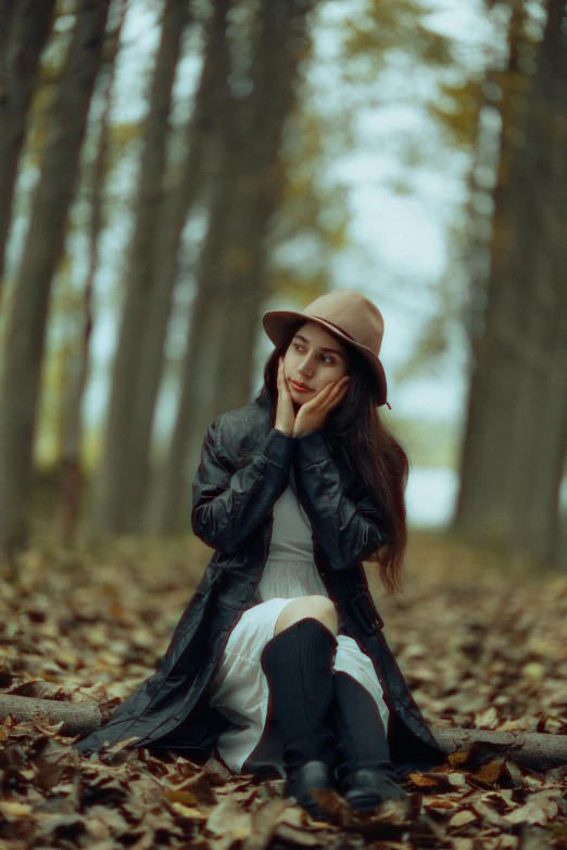 a woman with a hat sitting on the ground