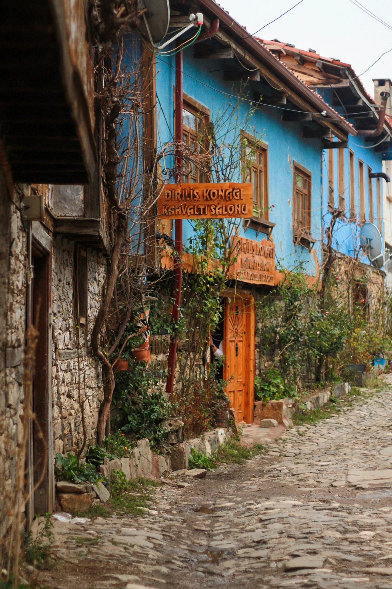 an old blue and brown building on cobblestone street