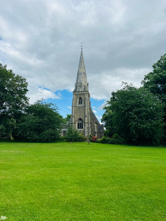 an old stone church on green grass