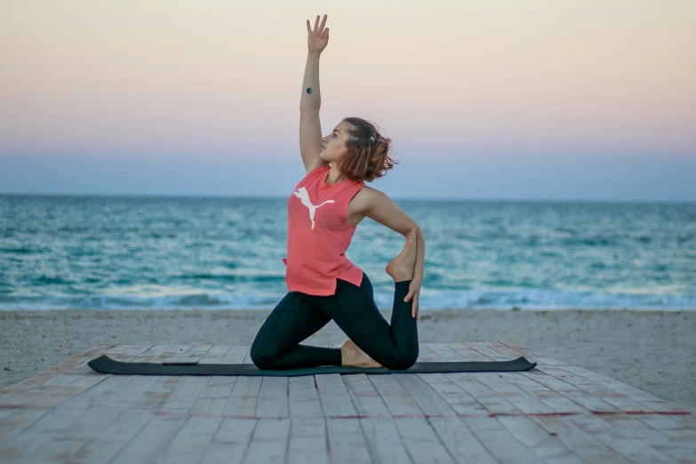 the woman is doing yoga on the beach