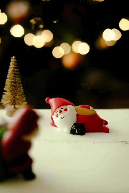 small toy santa's helper in front of a christmas tree