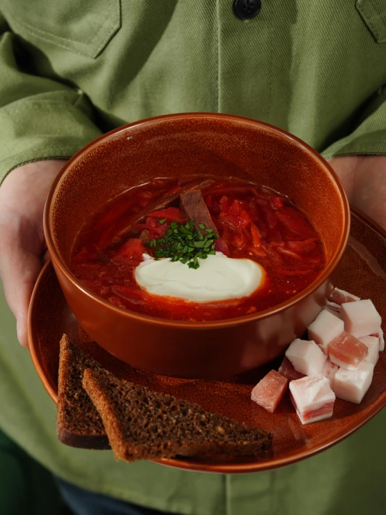 a person holding a bowl full of soup