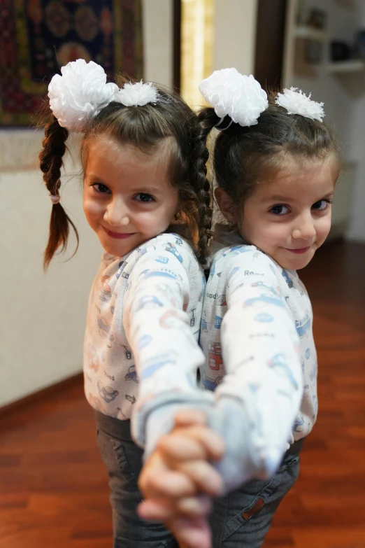 two girls are on the floor holding hands