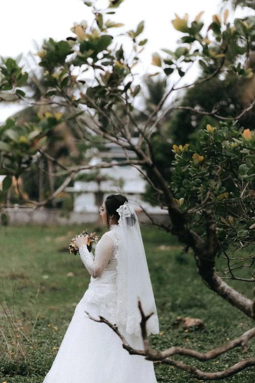 a woman in a wedding dress looks up at the sky