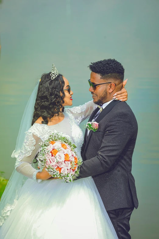 a bride and groom together with the reflection of water in the background