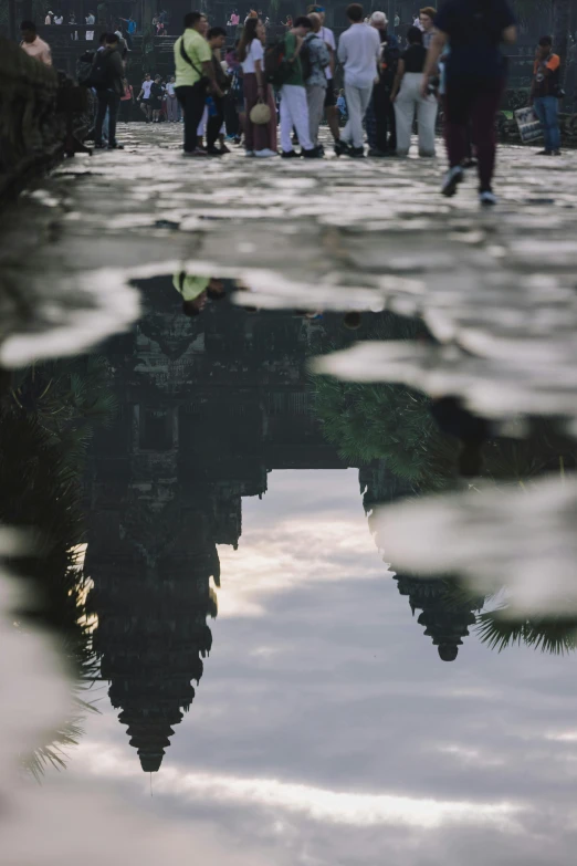 a crowd of people walking next to a large body of water