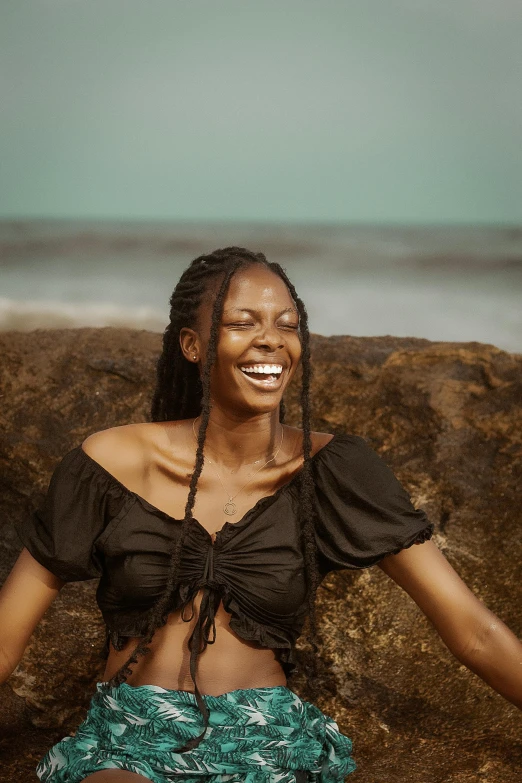 a woman is smiling while sitting on some rocks