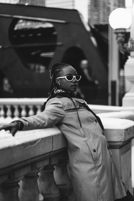 a woman in sunglasses leaning on a ledge