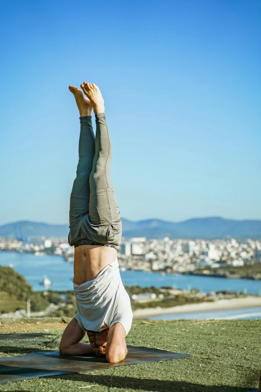 a person doing a handstand in front of the ocean