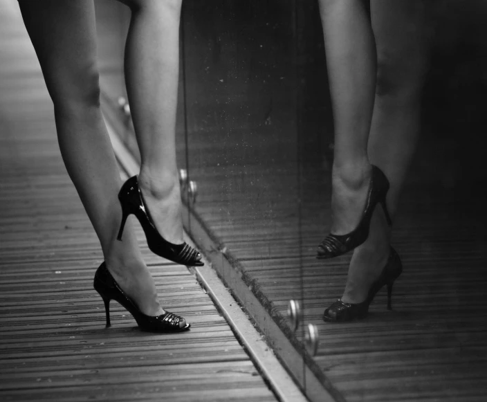 two women's legs in high heels on a wooden floor