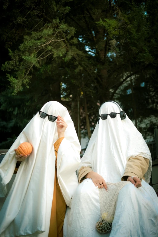 two men in white covered heads are holding a basketball