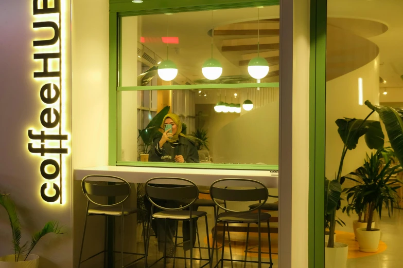 woman in window with her phone at counter