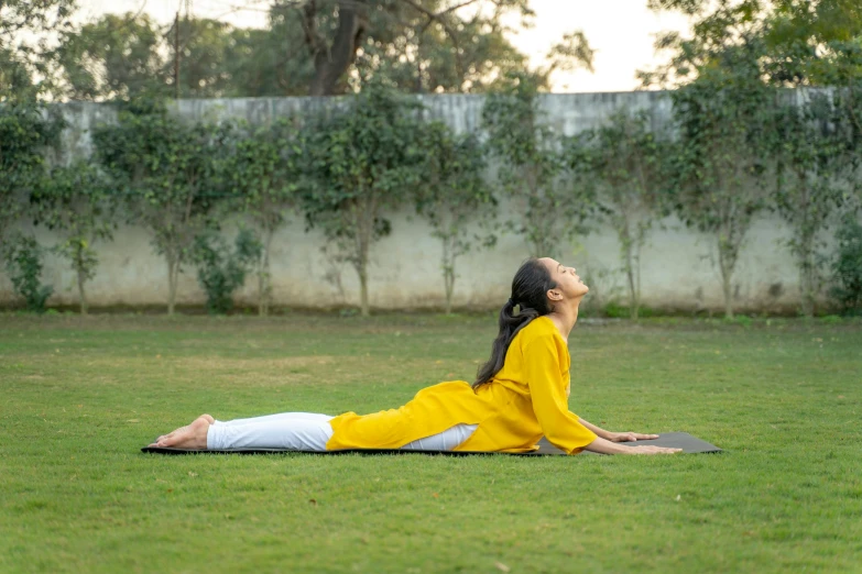 a  is sitting on a yoga mat outdoors