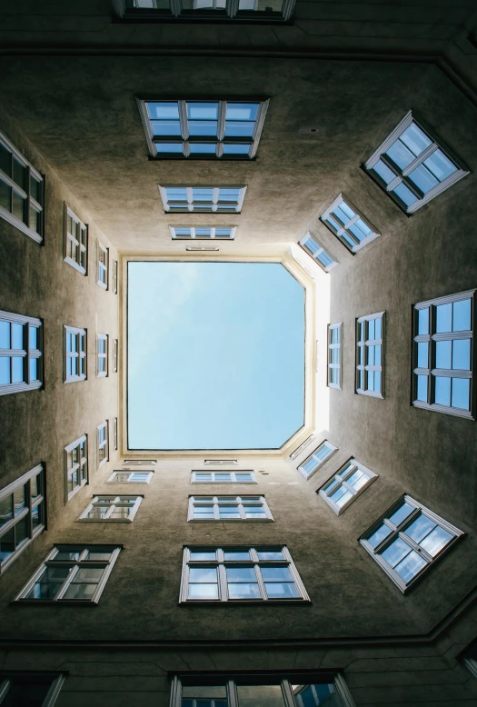 an upward view looking up into a window and sky