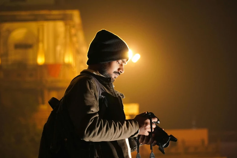 man with flashlight at night in dark with tractor