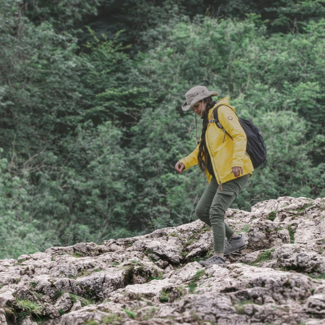 a man with a backpack stands on top of rocks