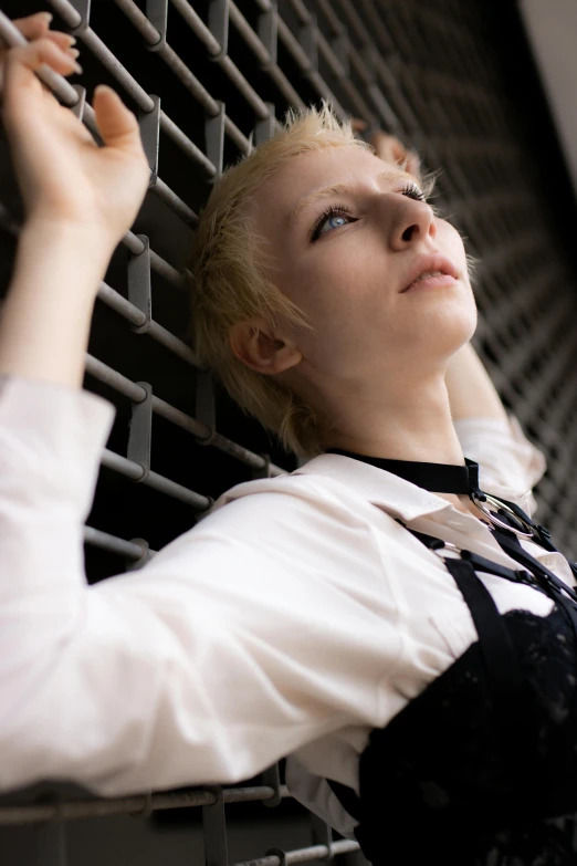 the woman in the jacket is leaning against the fence