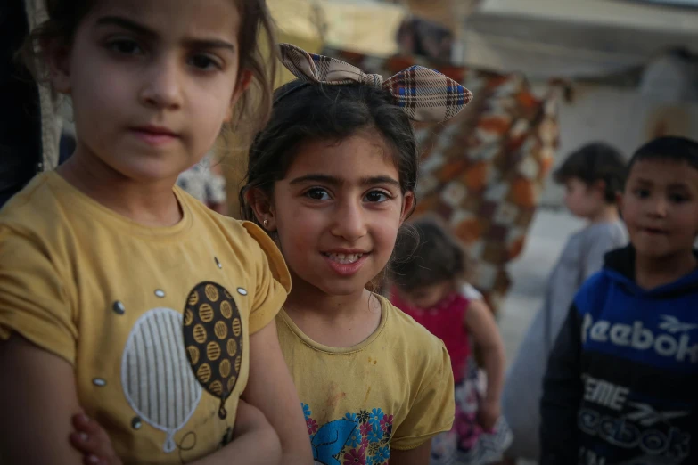 two girls in a market looking at the camera