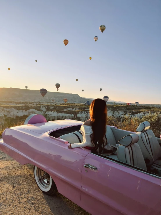 a woman driving in an old car in the desert