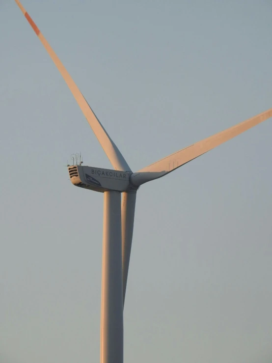 a white wind turbine with a small house on it