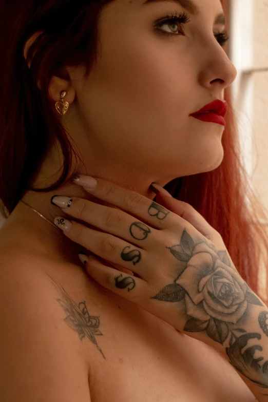 a tattooed woman with tattoos staring out a window