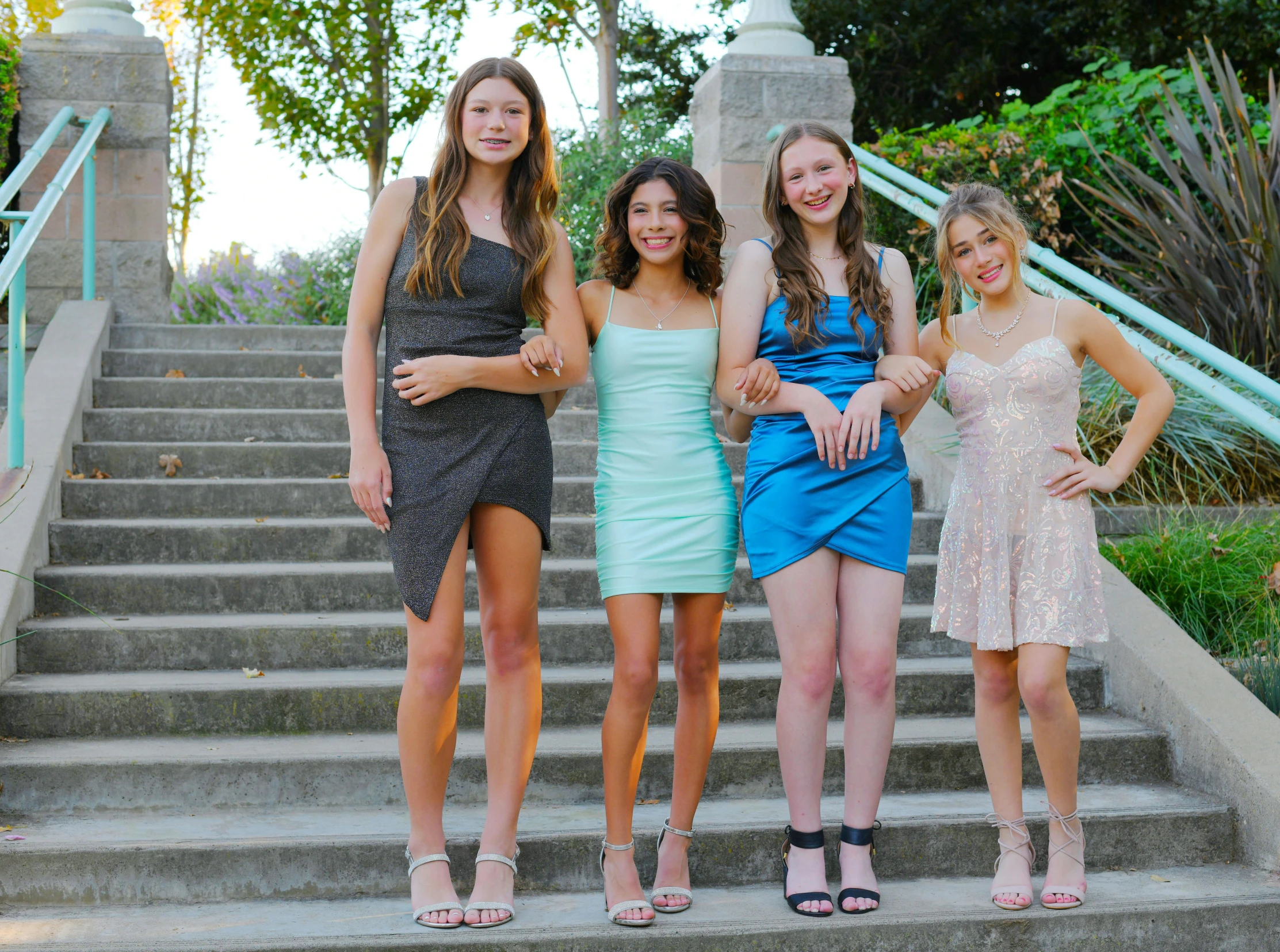 three girls standing in front of stairs with their arms crossed